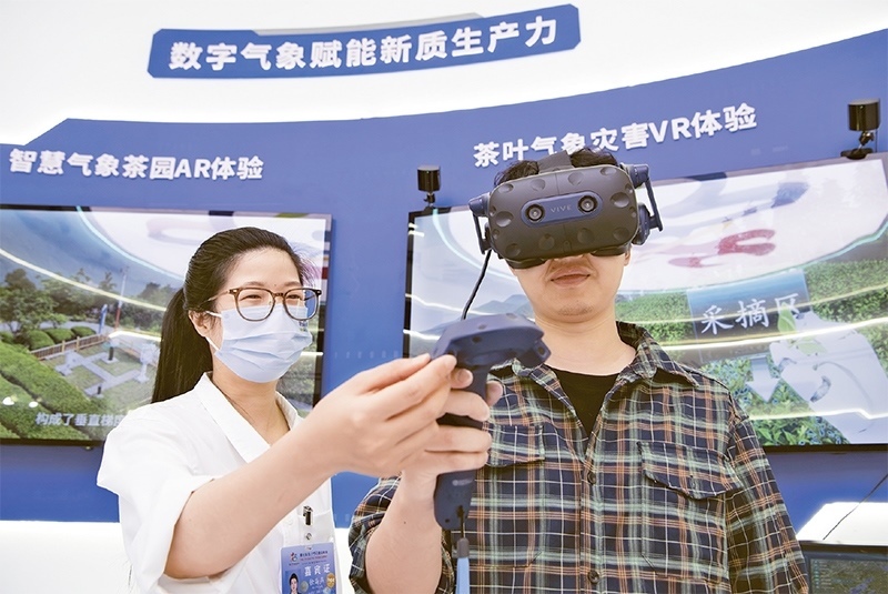 2024年5月23日，第七屆數(shù)字中國(guó)建設(shè)峰會(huì)現(xiàn)場(chǎng)體驗(yàn)區(qū)在福州海峽國(guó)際會(huì)展中心向?qū)I(yè)觀眾開放。本次現(xiàn)場(chǎng)體驗(yàn)區(qū)圍繞本屆峰會(huì)主題“釋放數(shù)據(jù)要素價(jià)值，發(fā)展新質(zhì)生產(chǎn)力”，設(shè)置“數(shù)字惠民”、“數(shù)字能力”、“數(shù)字基礎(chǔ)”、“數(shù)字生態(tài)”、“數(shù)字賦能”五大板塊。圖為一名觀眾（右）在數(shù)字氣象賦能新質(zhì)生產(chǎn)力展臺(tái)上進(jìn)行體驗(yàn)。 新華社記者 魏培全/攝