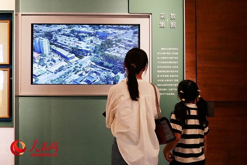 家長(zhǎng)正在帶孩子參觀“輝煌中軸”專題展。人民網(wǎng)記者 韋衍行攝
