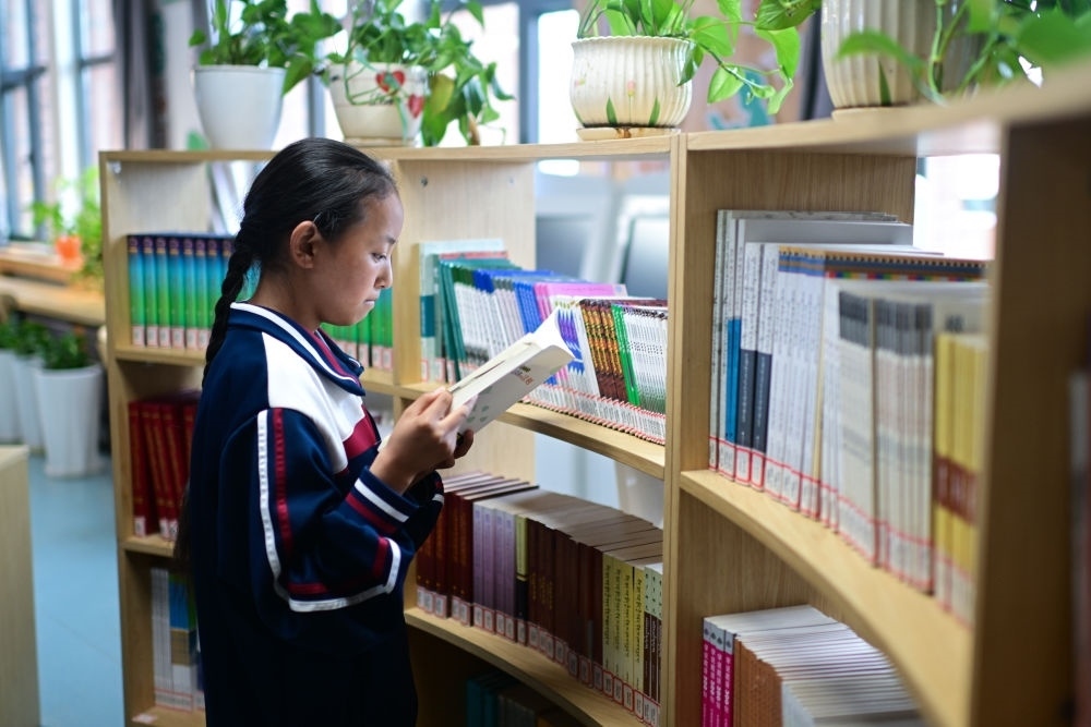 6月18日，果洛西寧民族中學(xué)學(xué)生尼東拉毛在圖書室看書。