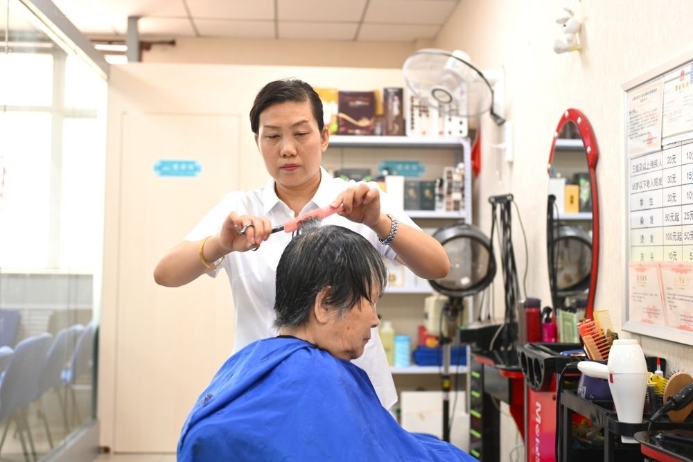 6月20日，長(zhǎng)城花園社區(qū)的志愿者為居民理發(fā)。