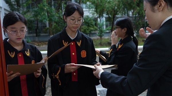 圖①：武平法院干警向?qū)W生分發(fā)道具卷宗。