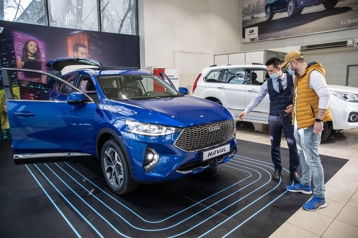 2021年4月1日，銷售人員在哈薩克斯坦阿拉木圖市經(jīng)銷商店向消費(fèi)者介紹哈弗汽車。新華社發(fā)（阿斯塔納汽車公司供圖）