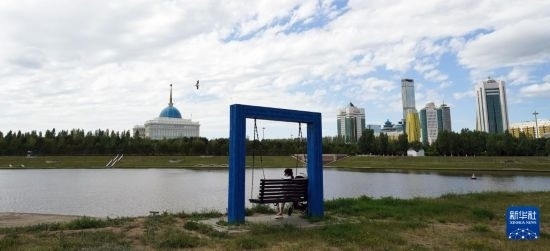 6月30日，一名女子在哈薩克斯坦首都阿斯塔納伊希姆河畔休息。新華社記者 王建華 攝