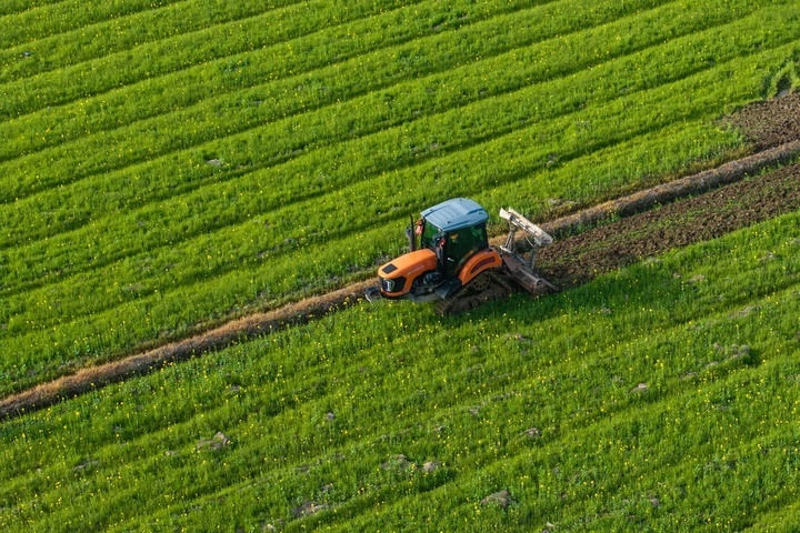 2024年3月19日，在湖南省常德市鼎城區(qū)謝家鋪鎮(zhèn)港中坪村，村民駕駛農(nóng)機(jī)翻耕田地（無(wú)人機(jī)照片）。新華社記者 陳思汗 攝