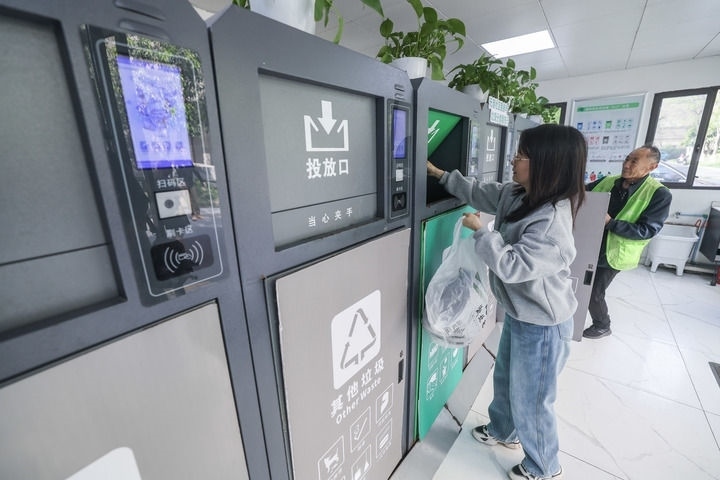 2024年4月10日，在浙江省湖州市吳興區(qū)飛英街道新華府小區(qū)內(nèi)，居民在垃圾分類智能系統(tǒng)的指導(dǎo)下進(jìn)行垃圾分類投放，居民的投放情況將實(shí)時(shí)匯總到智慧服務(wù)平臺(tái)，會(huì)有相應(yīng)的積分獎(jiǎng)勵(lì)。新華社記者 徐昱 攝