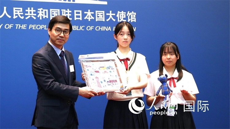 日本小大使向中國駐日本大使館臨時代辦施泳贈送當(dāng)?shù)靥厣Y品。人民網(wǎng) 許可攝