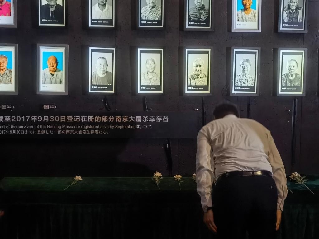 7月18日，人們向離世的南京大屠殺幸存者獻花、鞠躬。新華社記者邱冰清 攝