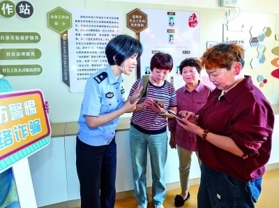 浙江湖州民警指導(dǎo)居民加入湖州“e企安”微信群，實(shí)時(shí)接收反詐信息。新華社發(fā)