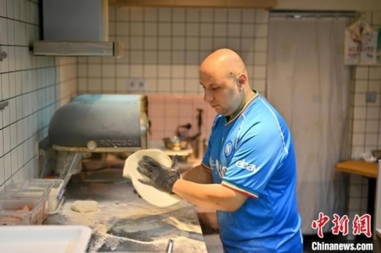 近日，韋榮耀在自家披薩小店內(nèi)忙活。俞靖 攝