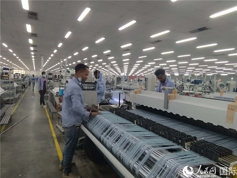無錫金茂埃塞面料廠車間內(nèi)，當(dāng)?shù)毓と苏谝唤z不茍地作業(yè)。人民網(wǎng)記者 黃培昭攝