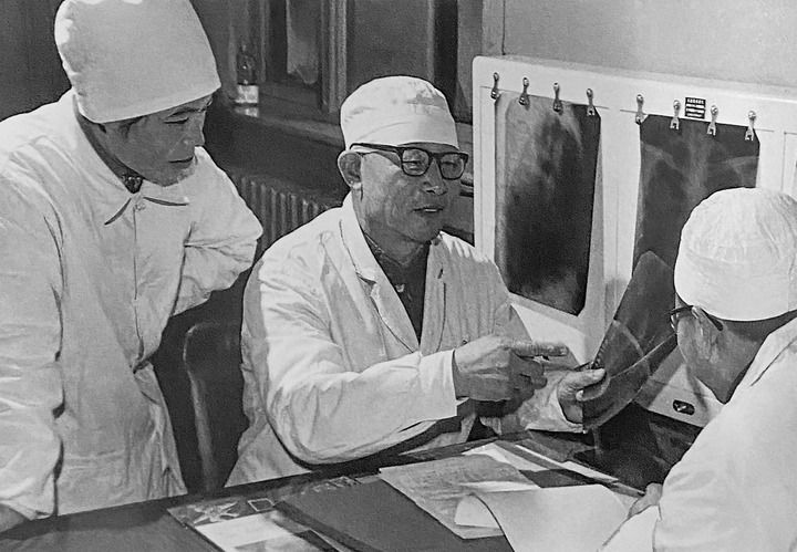 1980年1月16日，中日友好醫(yī)院首任院長辛育齡（中）在內(nèi)蒙古結(jié)核病院與胸外科醫(yī)師討論病例（翻拍照片）。 新華社發(fā)