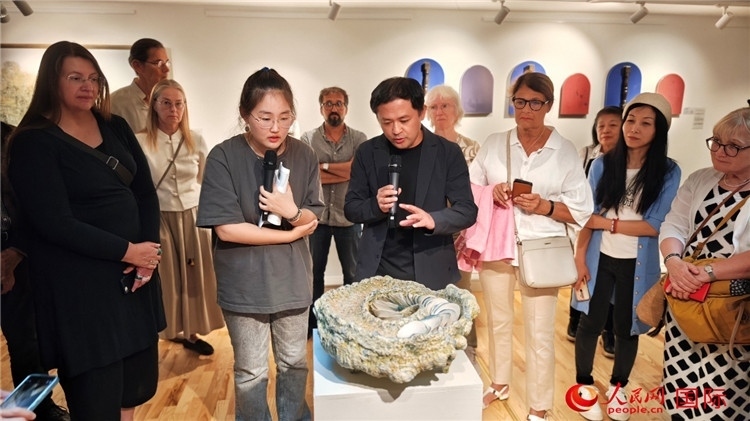 參展人、景德鎮(zhèn)陶瓷大學設計藝術學院副院長余劍峰（中）向來賓介紹參展作品。人民網(wǎng)記者 殷淼攝