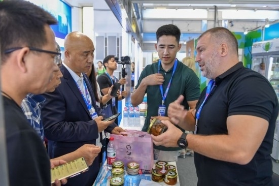 2023年8月23日，在第十四屆中國—東北亞博覽會(huì)東北亞商品館，俄羅斯參展商向參觀者介紹商品。