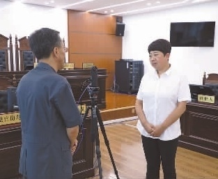 圖為全國人大代表玉明姬(右)詳細了解環(huán)境資源審判工作情況。劉思妤 攝