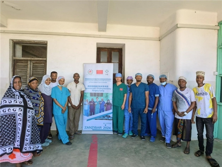 隊(duì)長蔣國慶（右七）和手術(shù)醫(yī)生、部分患者合影。中國援桑醫(yī)療隊(duì)供圖