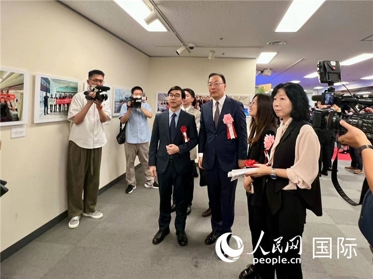 中國(guó)國(guó)際航空日韓地區(qū)支社支社長(zhǎng)馮力為中國(guó)駐日本大使館臨時(shí)代辦施泳等嘉賓介紹展出圖片。人民網(wǎng) 許可攝