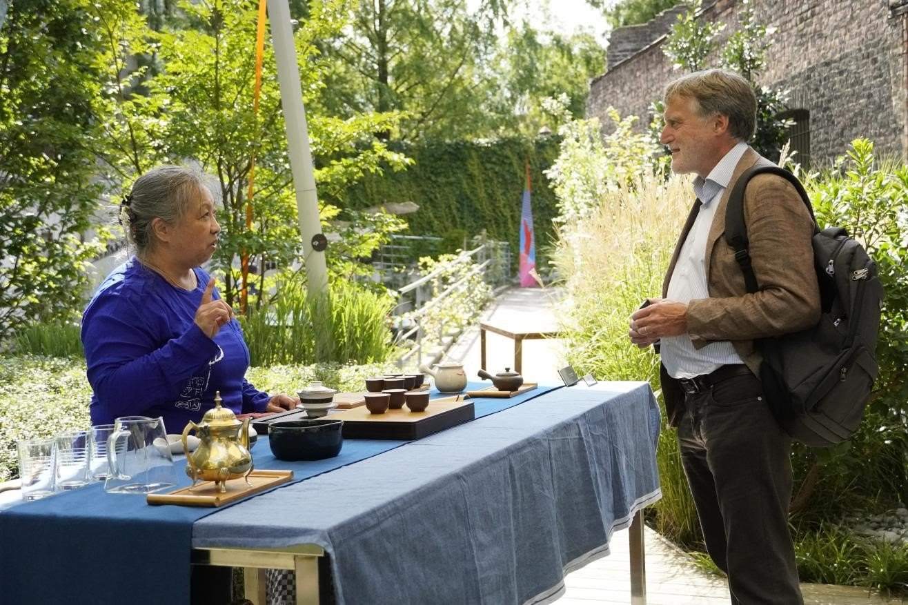 在博物館的戶外花園來賓品味中國茶藝。比利時維他命文化傳媒供圖