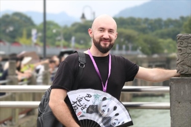 俄羅斯塔斯社執(zhí)行編輯葉夫根尼·扎多羅日內(nèi)在都江堰魚嘴拍照留念。（李佩藺 攝）