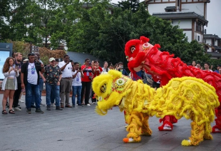 2024“一帶一路”媒體合作論壇聯合采訪調研行成員在樂山蘇稽古鎮(zhèn)觀看非遺舞獅表演。本報記者 伊霄攝