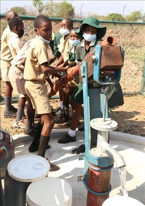 △2021年11月，在津巴布韋南馬塔貝萊蘭省省會關(guān)達(dá)的塞農(nóng)多小學(xué)，學(xué)生從中國援建水井里打水。