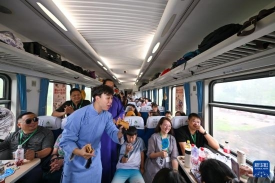 9月7日，相聲演員在S910列車上為旅客表演快板。