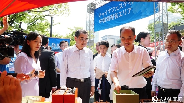 湖南展位工作人員向中國駐日本大使吳江浩介紹特色文創(chuàng)產(chǎn)品。人民網(wǎng) 蔣曉辰攝