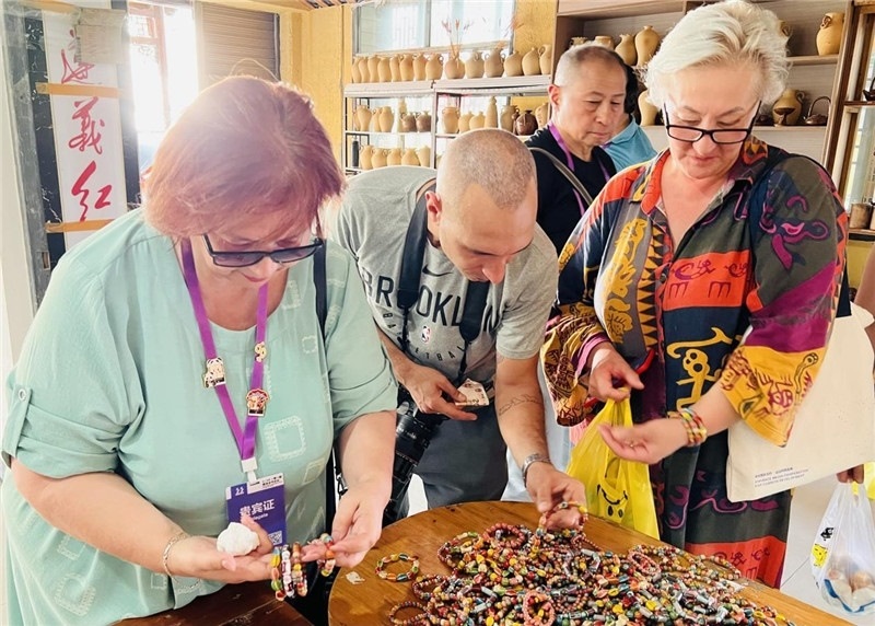 歐亞媒體考察團成員在母氏陶藝館內挑花了眼，色彩絢麗、質地均勻的陶藝手串讓他們愛不釋手。“這里的東西都太實惠了！”塔吉克斯坦《索格特真理報》政論部主任娜塔利婭·多羅費耶娃說?；宓奶厣a品物美價廉，讓考察團成員為家人好友買到了心儀的禮物，也為此次以四川成都為起點，路經南充、廣安至貴州遵義的考察行程畫上了圓滿句號。（張亞欣攝）