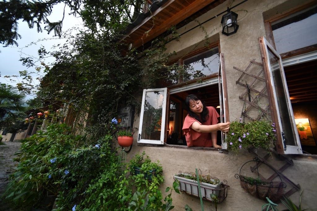 8月29日，在福建省屏南縣熙嶺鄉(xiāng)，龍?zhí)洞濉靶麓迕瘛泵泛暝诖蚶碜约航?jīng)營的民宿外墻裝飾花盆。新華社記者姜克紅 攝