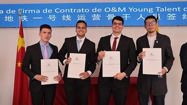 當?shù)貢r間9月13日，40名哥倫比亞青年與中企承建運營的波哥大地鐵一號線項目簽約，不久將前往中國進行為期15個月的專業(yè)地鐵知識培訓。圖為部分學員在簽約儀式上展示所簽的協(xié)議。 波哥大地鐵一號線項目供圖