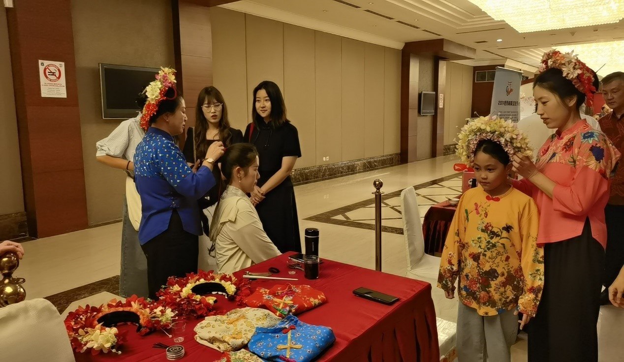 阿拉扎大學(xué)孔子學(xué)院志愿者老師向傳承人學(xué)習(xí)簪花圍。阿拉扎大學(xué)孔子學(xué)院供圖