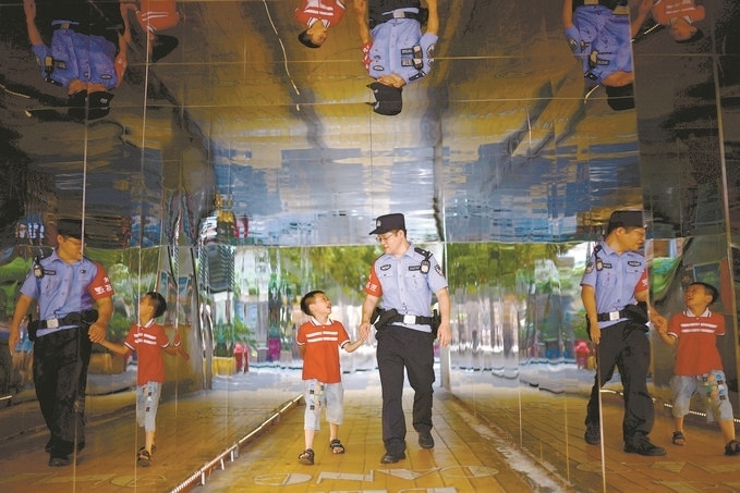 ?7月16日，重慶市公安局江北區(qū)分局一名民警在巡邏途中遇到一個獨自玩耍的小男孩，民警將其送回家。王洪平攝