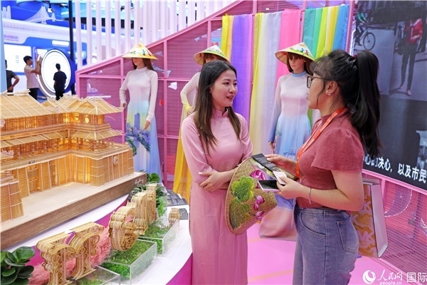 參觀者在東博會(huì)越南展區(qū)同工作人員咨詢交談。人民網(wǎng)記者 趙益普攝