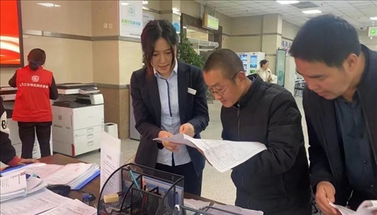 四川省成都市溫江區(qū)市場(chǎng)監(jiān)管局工作人員為群眾提供幫辦服務(wù)。圖片來(lái)源：人民網(wǎng)四川頻道