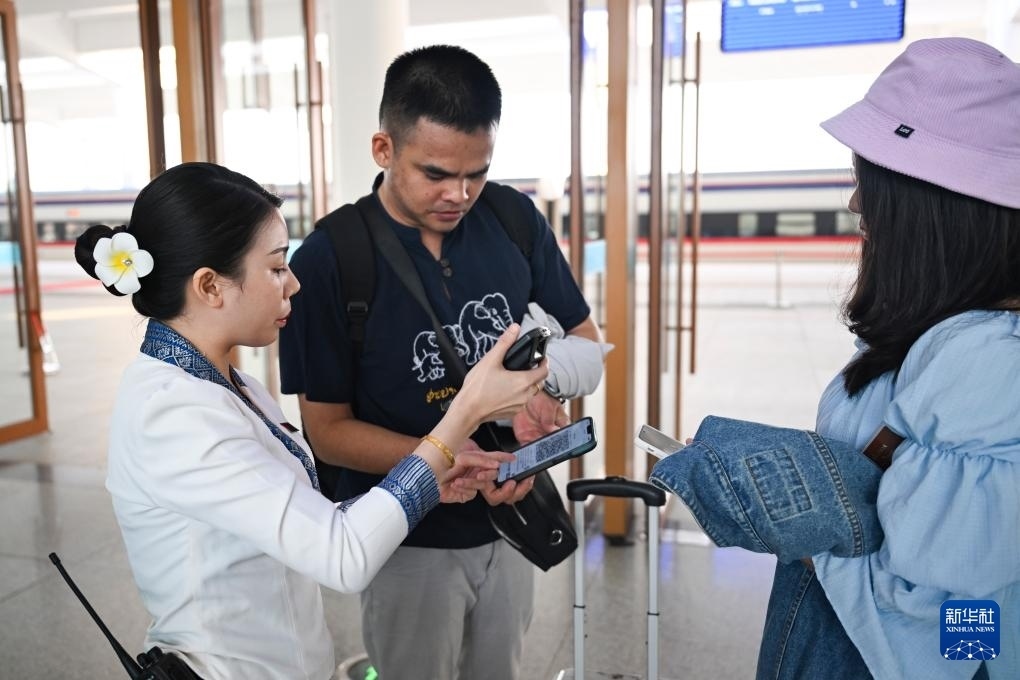 10月12日，在老撾萬象中老鐵路萬象站，工作人員檢驗乘客車票。新華社記者 程一恒 攝