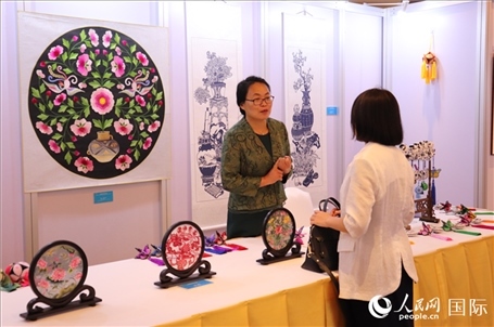 青海非遺文化傳承人向嘉賓介紹展品。人民網(wǎng)實(shí)習(xí)生姚欣可攝