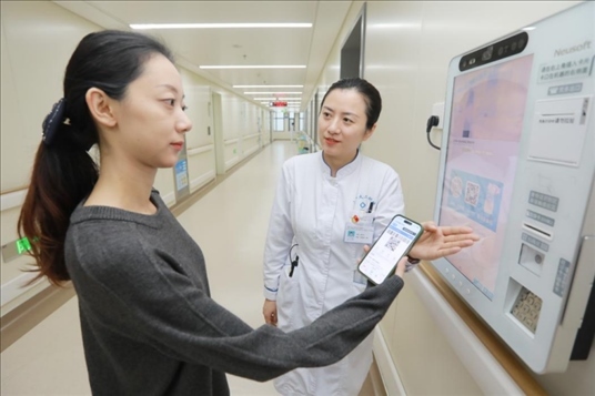 醫(yī)護(hù)人員引導(dǎo)患者在自助機前辦理自助入院手續(xù)。圖片來源：山東第一醫(yī)科大學(xué)第二附屬醫(yī)院