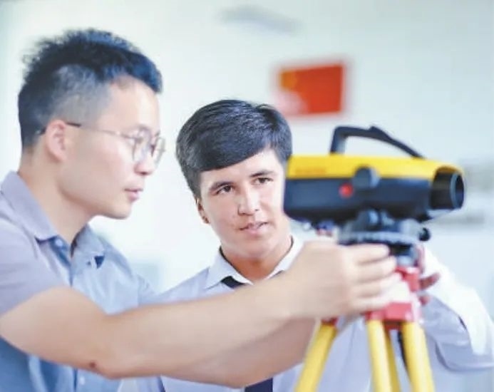 在塔吉克斯坦首都杜尚別的魯班工坊，來(lái)自天津城市建設(shè)管理職業(yè)技術(shù)學(xué)院的老師（左）為當(dāng)?shù)貙W(xué)生提供指導(dǎo)。新華社記者 鄭開(kāi)君 攝