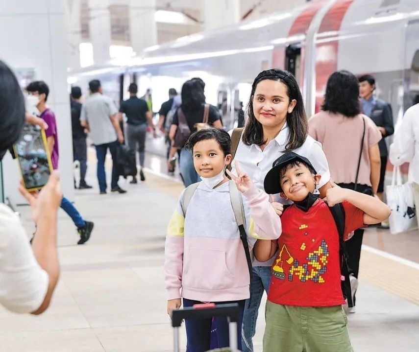 雅萬(wàn)高鐵是我國(guó)在境外完成全過(guò)程勘察設(shè)計(jì)建設(shè)的首個(gè)高鐵項(xiàng)目，于去年10月17日正式開(kāi)通運(yùn)營(yíng)，是中印尼共建“一帶一路”合作的典范。圖為乘客在和雅萬(wàn)高鐵動(dòng)車(chē)組合影留念。新華社記者 徐欽 攝