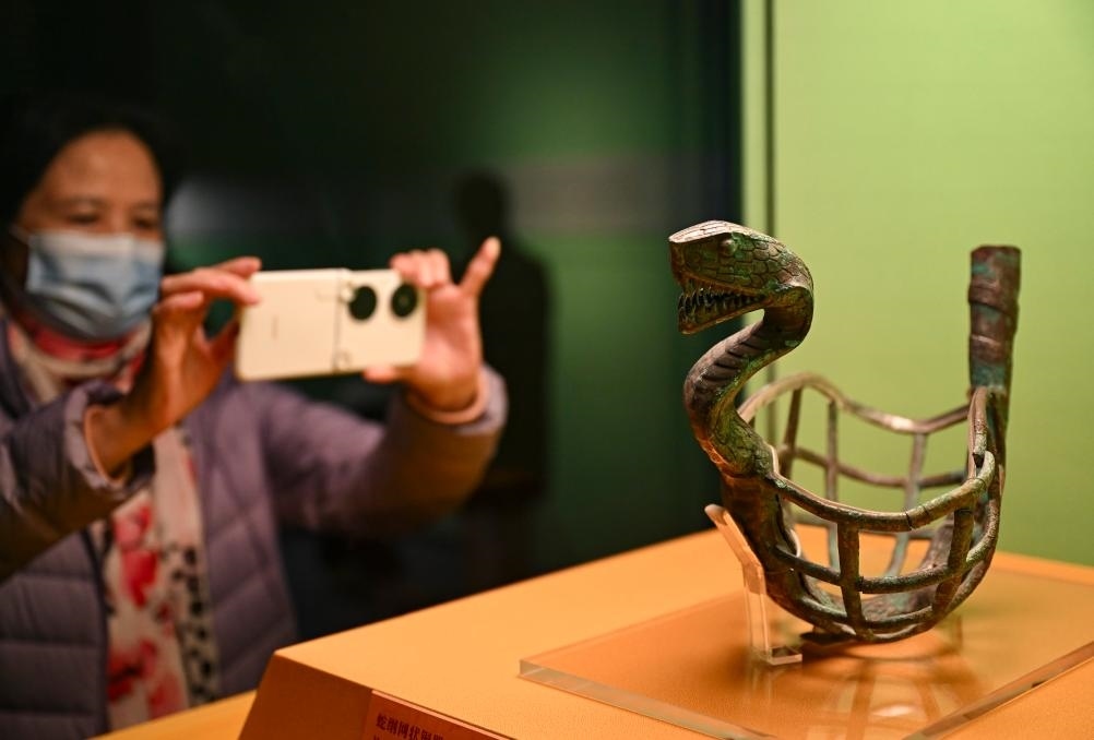 1月14日，觀眾在上海博物館蛇年迎春展拍攝展品蛇綱網(wǎng)狀銅器。新華社發(fā)（陳浩明攝）