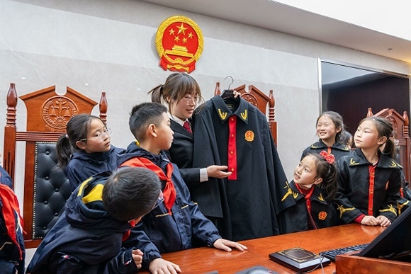 圖②:干警向同學(xué)們介紹法袍。