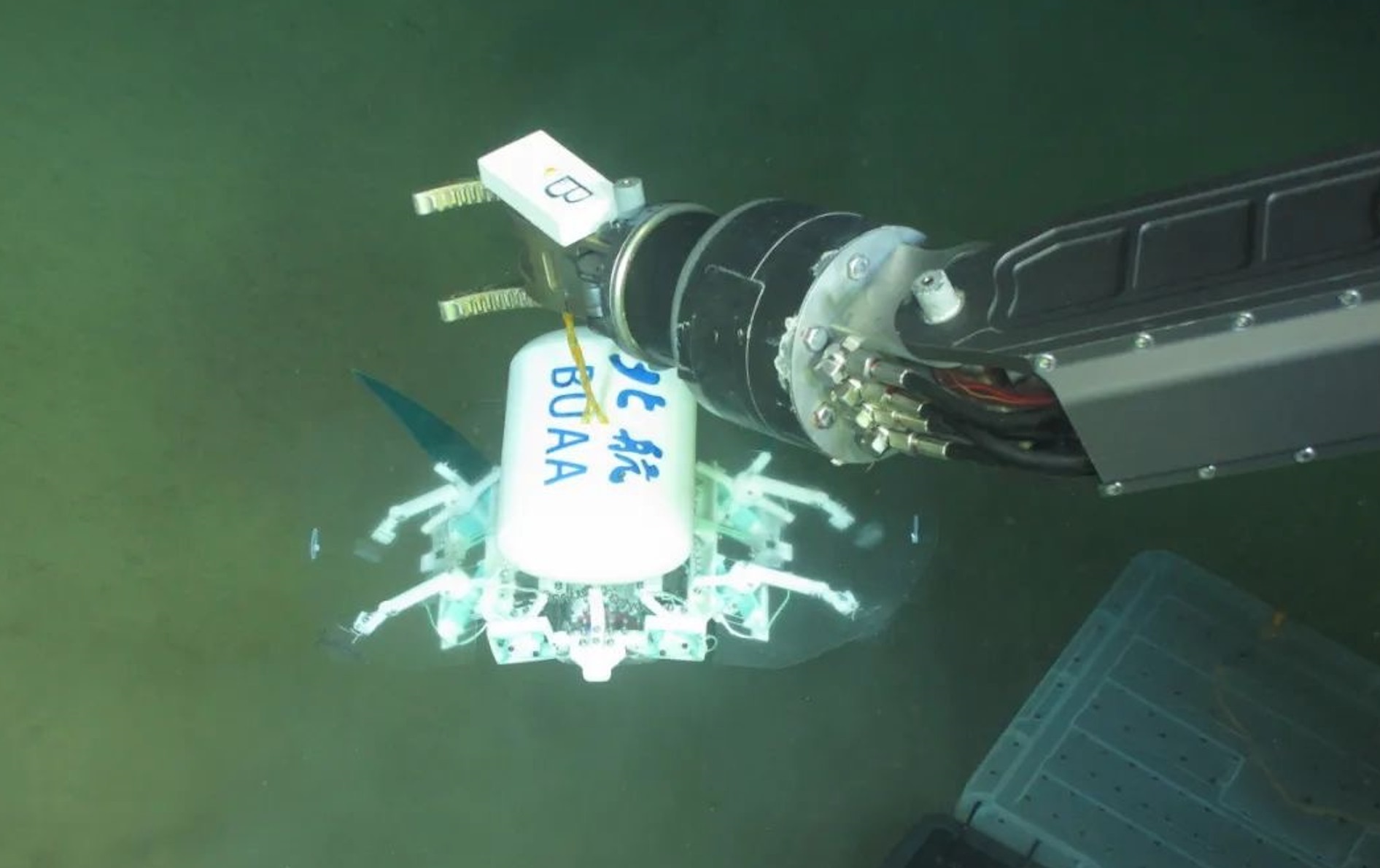 科研人員利用機(jī)械臂將北航深海小型機(jī)器人投于馬里亞納海溝。校方供圖