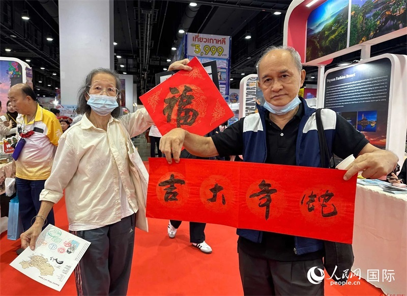 2025蛇年春節(jié)，泰國市民展示他們領到的華人手寫春聯(lián)。人民網(wǎng)記者 簡承淵攝