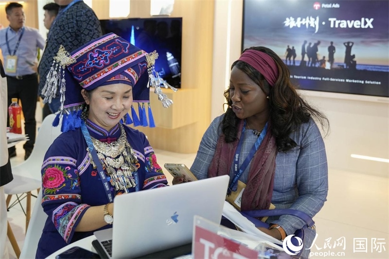 來(lái)自廣西的旅游業(yè)者同客戶(hù)交流。人民網(wǎng)塔里克·易卜拉欣攝