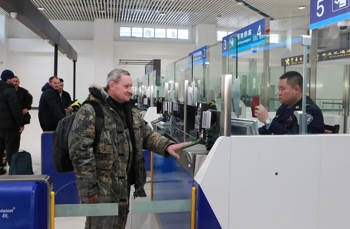 2024年12月10日，在黑河公路口岸旅檢大廳，黑河出入境邊防檢查站民警為首班次客車入境旅客辦理邊檢通關(guān)手續(xù)。當(dāng)日，中國(guó)黑河公路口岸—俄羅斯卡尼庫(kù)爾干公路口岸旅客運(yùn)輸正式開(kāi)通。新華社發(fā)（劉松攝）