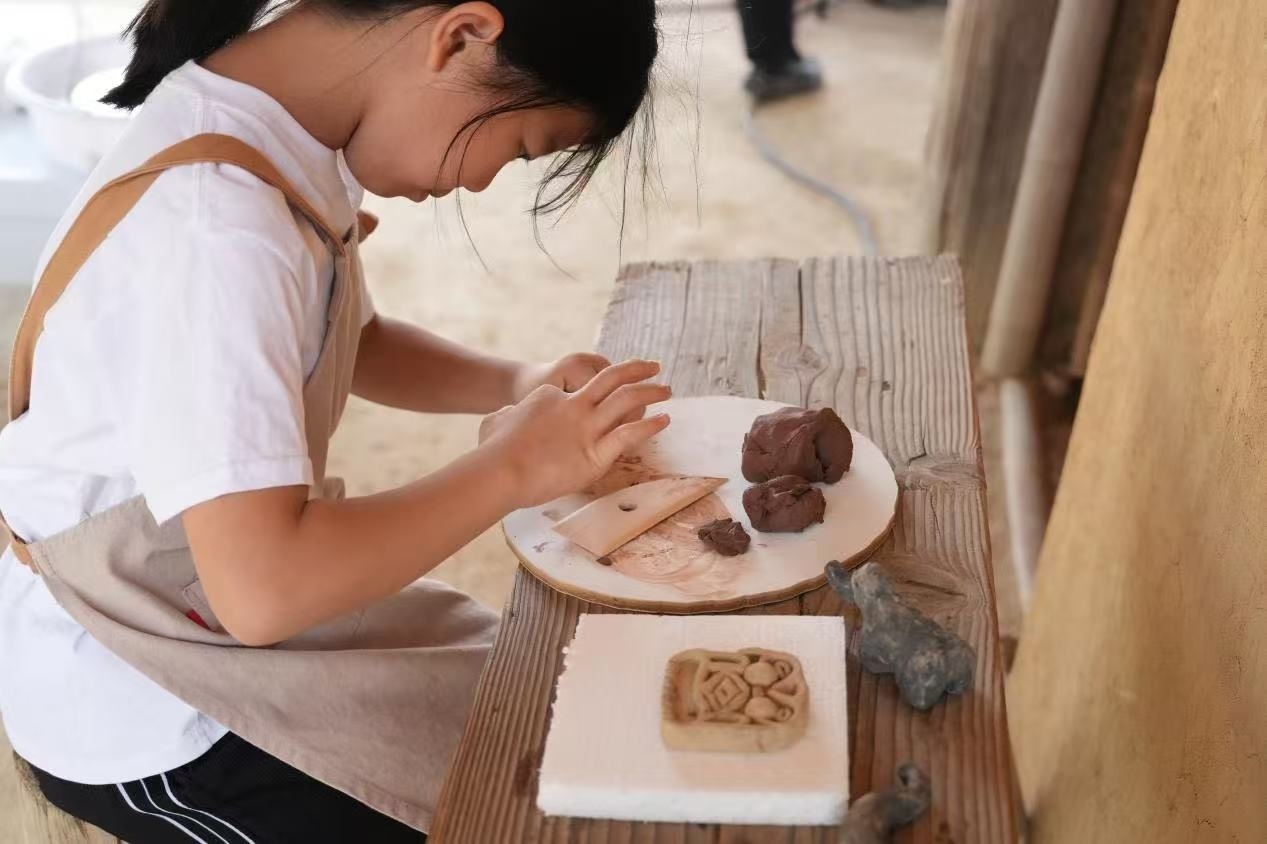 游客制作良渚特色陶藝品。良渚博物院供圖
