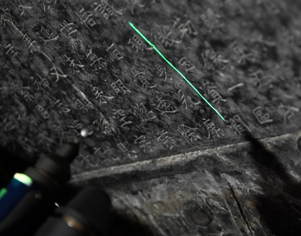 2025年4月9日，龍門(mén)石窟研究院工作人員在古陽(yáng)洞使用關(guān)節(jié)臂掃描儀對(duì)《龍門(mén)二十品》之一進(jìn)行數(shù)字化掃描。新華社記者 李嘉南 攝