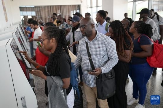 5月31日，在蒙內(nèi)鐵路內(nèi)羅畢站，乘客在自助取票機(jī)前排隊(duì)取票。新華社記者 楊光 攝