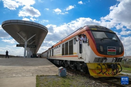 5月31日，在蒙內(nèi)鐵路內(nèi)羅畢站，機(jī)車駕駛員蔣立平（右）和博爾在即將開往蒙巴薩的E2次列車上揮手致意。新華社記者 楊光 攝