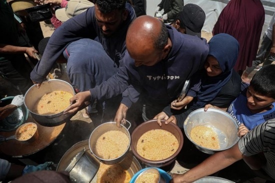 5月28日，人們?cè)诩由吵俏鞑康纳程犭y民營領(lǐng)取救助食物。新華社發(fā)（里澤克·阿卜杜勒賈瓦德攝）