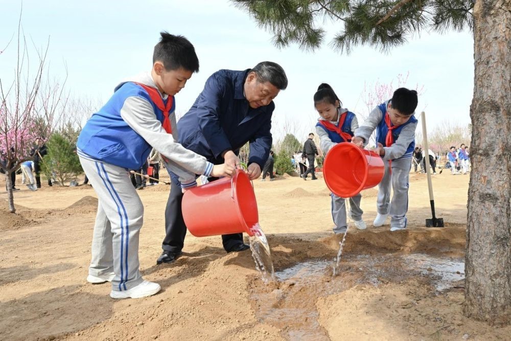 2025年4月3日，習近平總書記等來到北京市豐臺區(qū)永定河畔參加首都義務(wù)植樹活動。這是習近平總書記同少先隊員一起給剛栽下的樹苗澆水。新華社記者 謝環(huán)馳 攝
